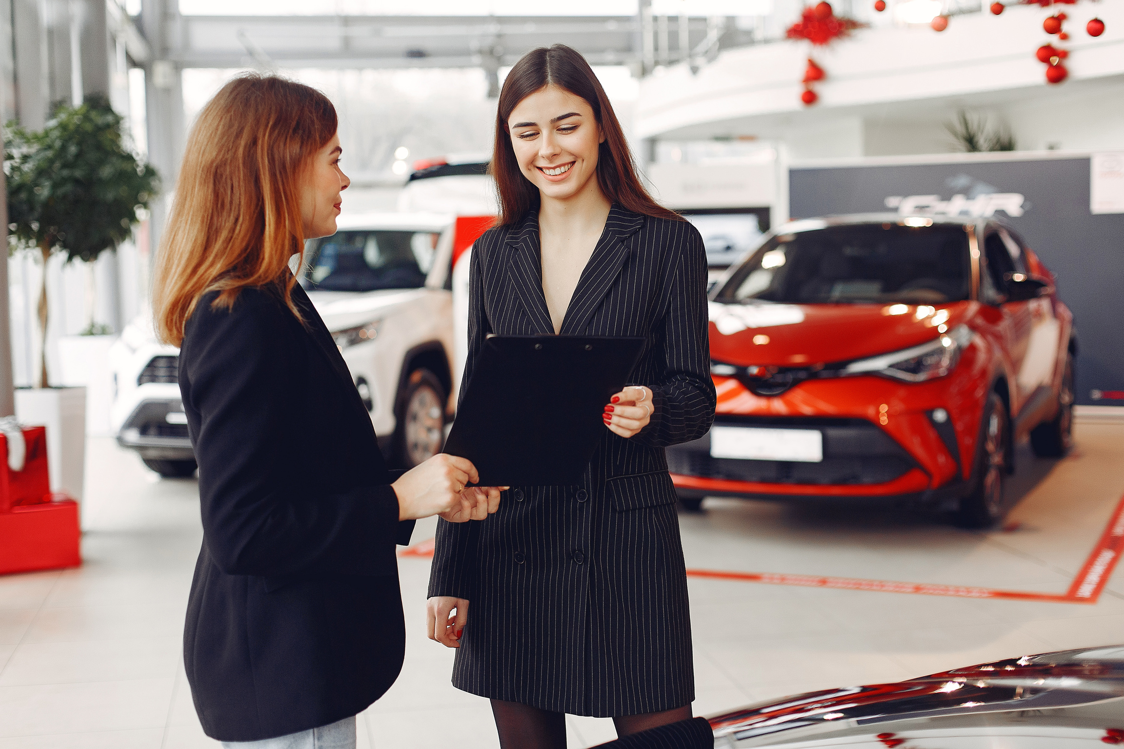 Female Car Dealer Holding a Contract 